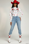 Beautiful model wearing baby blue rhinestone boot cut jeans white top and red white blue cowgirl hat with red rose